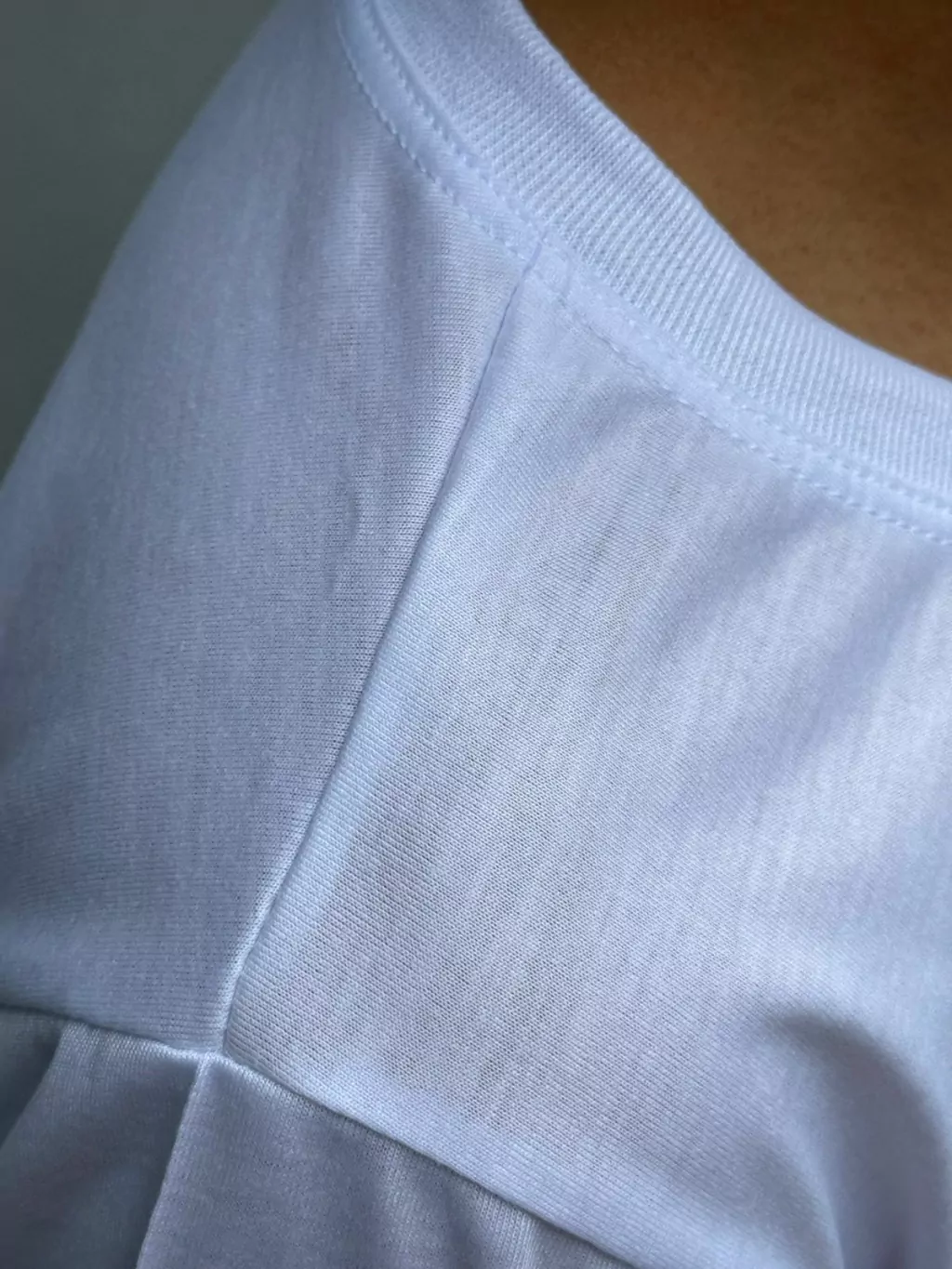 Camiseta branca poliéster – detalhe do decote e acabamento superior