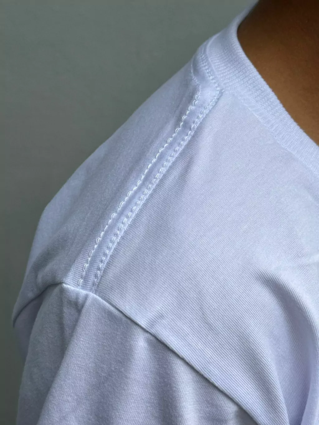 Camiseta branca algodão penteado – detalhe do decote e reforço ombro a ombro