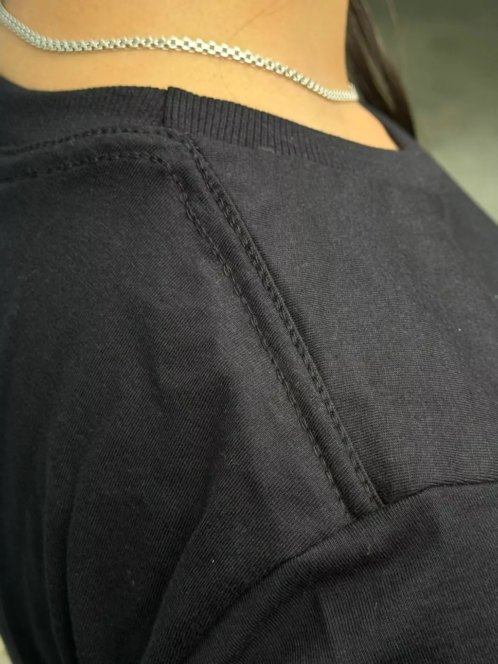 Baby look preta feminina – vista de cima mostrando gola e reforço ombro a ombro
